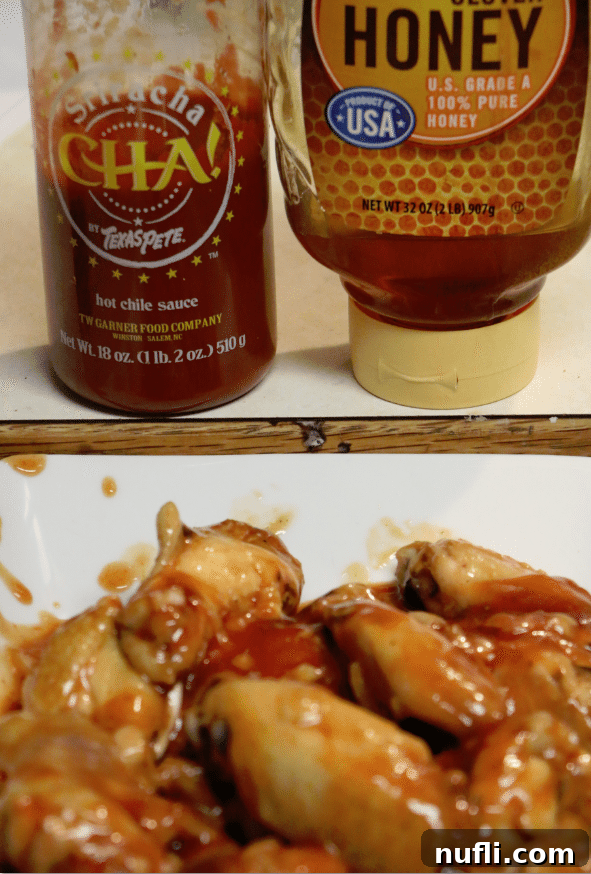 Close-up of sticky honey sriracha chicken wings on a platter, with a bottle of CHA! by Texas Pete and a honey pot in the background.