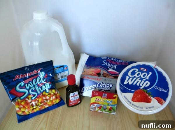 Essential ingredients for Candy Corn Cheesecake Mousse: candy corn, milk, powdered sugar, food coloring, and Cool Whip, neatly arranged on a kitchen counter