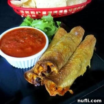 Crispy Corn and Black Bean Baked Taquitos 3 Corn and Black Bean Baked Taquitos on a black plate next to salsa