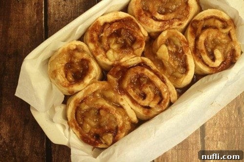 Unbaked Homemade Apple Cinnamon Rolls neatly arranged in a baking dish, perfectly risen and ready for the oven.