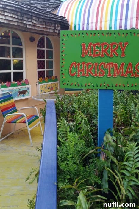 The Bubble Room Captiva Island Where Whimsy Meets Florida Charm 3 A brightly lit 'Merry Christmas' sign adorned with festive decorations at the entrance of The Bubble Room, indicative of its year-round holiday theme.