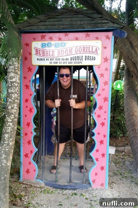 The Bubble Room Captiva Island Where Whimsy Meets Florida Charm 6 A visitor, John, playfully posing in a humorous 'Bo Bo Bubble Room Gorilla' standee at The Bubble Room gift shop, illustrating the fun and interactive elements.