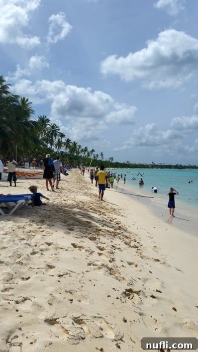 Bayahibe Beach Escape in La Romana, Dominican Republic 3 Vibrant scene of people relaxing on a tropical beach, enjoying the sun, sand, and ocean views.
