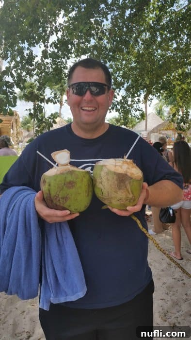 Bayahibe Beach Escape in La Romana, Dominican Republic 5 A person happily holding two fresh coconuts, ready to enjoy a refreshing tropical drink.
