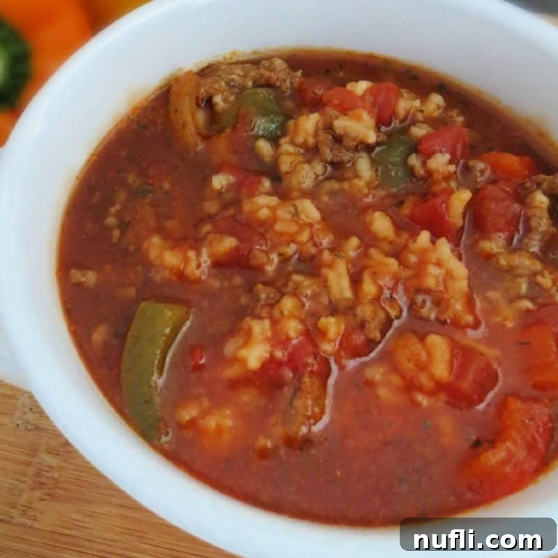 Crockpot Stuffed Pepper Soup in a white bowl with peppers in the background