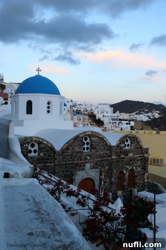 Picturesque view of the iconic blue-domed churches and white-washed buildings of Santorini, gleaming under the bright Mediterranean sun.