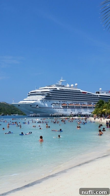 Mahogany Bay Roatan Cruise Haven 8 Carnival cruise ship in the background of people playing at the beach and in the water.