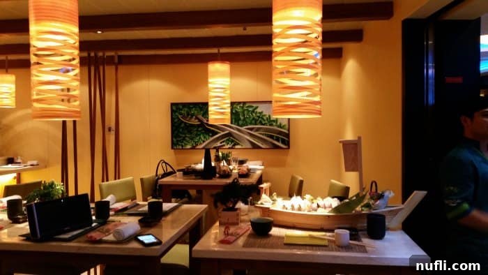 Carnival Sunshine Dining Guide 7 Bonsai Sushi restaurant with tables, chairs, and lanterns from the ceiling, Sushi boat on a table
