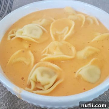 Slow Cooker Tomato Tortellini Soup in a white bowl