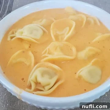 Slow Cooker Tomato Tortellini Soup in a white bowl