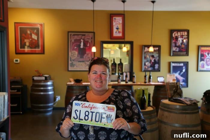 Tammilee holding a license plate in Slight of hand winery 