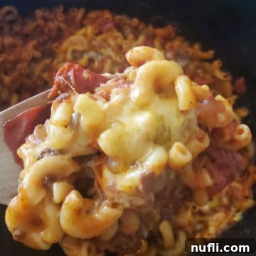 Cheesy Chili Mac Perfection in Your Crock Pot 4 Chili mac and cheese on a wooden spoon over a slow cooker