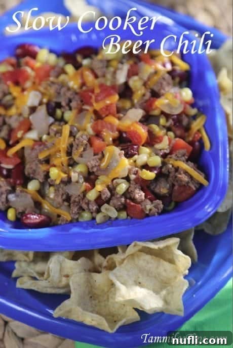 Slow Cooker Beer Chili over a blue bowl of chili and chips