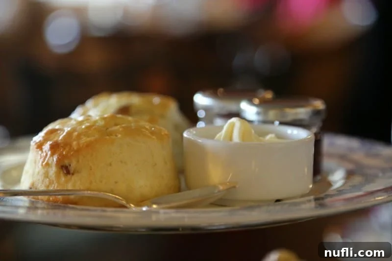 Close-up of freshly baked scones, jam, and Empress cream artfully arranged on a dessert plate.