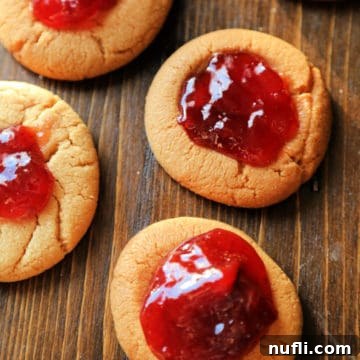 PB&J Stuffed Delights 3 Peanut Butter and Jelly Cookies on a wood cutting board