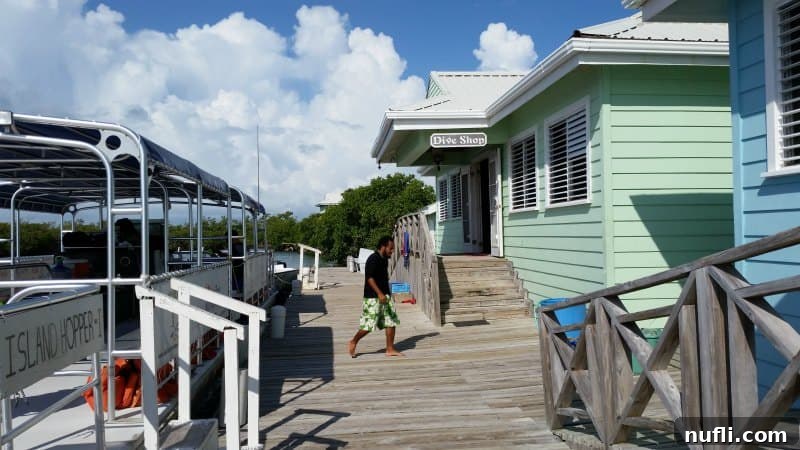 Exterior view of a dive shop with a boat moored next to its dock in Belize, showing preparations for a marine excursion