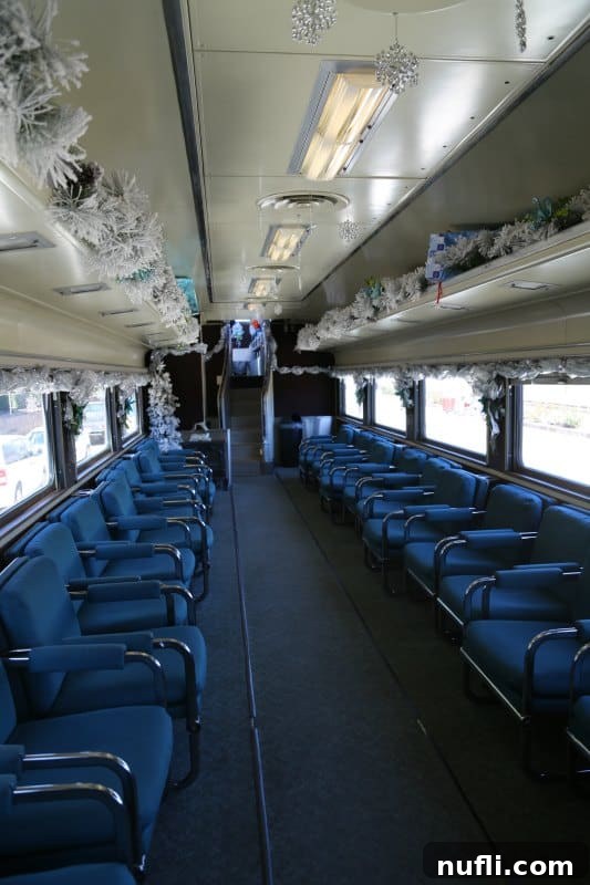 A beautifully decorated rail car, ready for passengers to enjoy their scenic journey. Rail car interior with festive decorations and comfortable seating arrangements facing inward