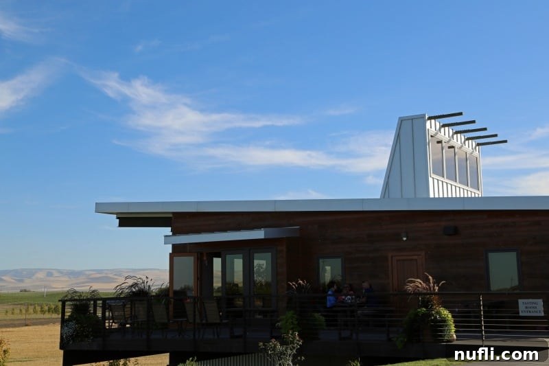 Exterior of Amavi Cellars with fields in the background, showcasing its elegant architecture and scenic vineyard surroundings