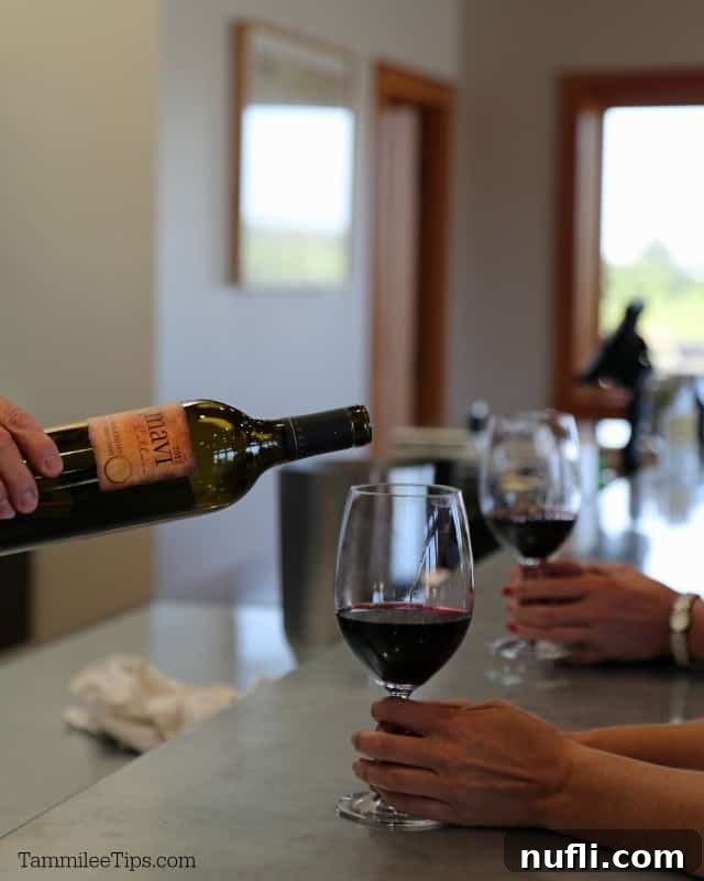 A skilled hand gently pouring Amavi Wines into a glass, highlighting the rich color and clarity of the wine