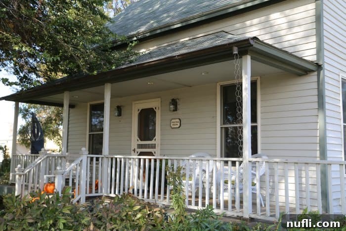The charming and welcoming exterior of Woodward Canyon Winery, nestled amidst green foliage under a clear sky.