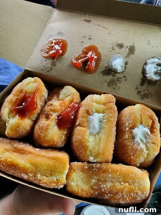 Epic Eats on Hawaii's Big Island: Top Restaurant Picks 4 Freshly made malasadas in a box with various fillings on top