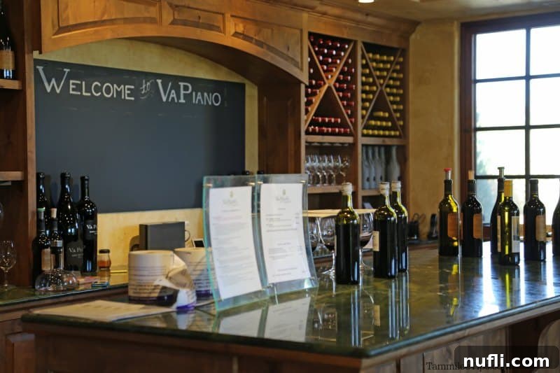 Welcome to Va Piano behind the bar with bottles lined on the counter 