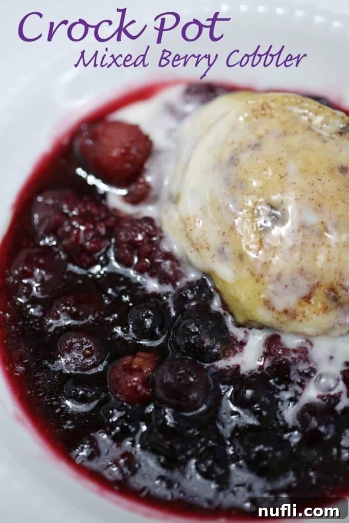Crockpot Mixed Berry Cobbler served over in a white bowl, ready to be enjoyed.
