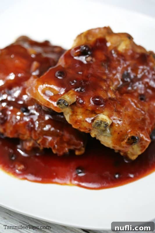 A close-up of delicious huckleberry ribs served on a white plate, ready to be enjoyed.