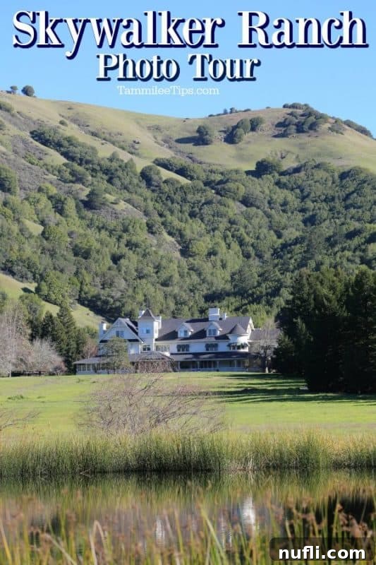 A majestic white Victorian-style building, the Main House of Skywalker Ranch, nestled amidst rolling green hills under a clear sky. The landscape hints at the vastness and natural beauty of the ranch.
