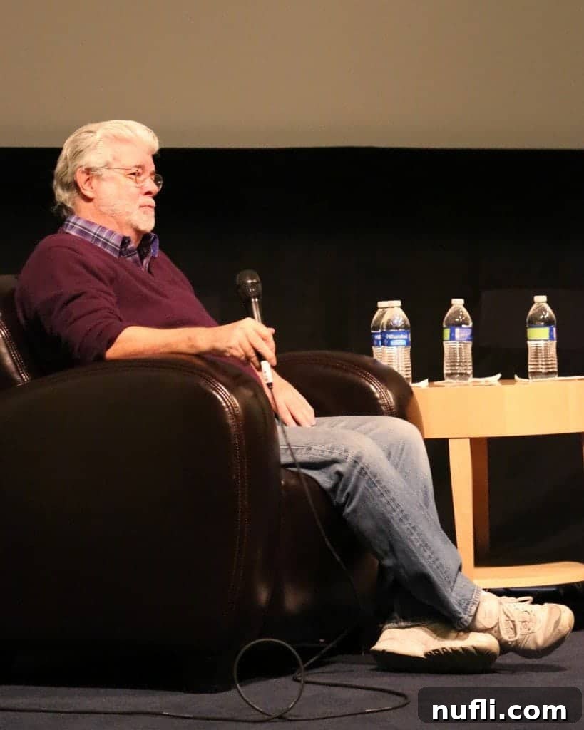 George Lucas on stage holding a microphone