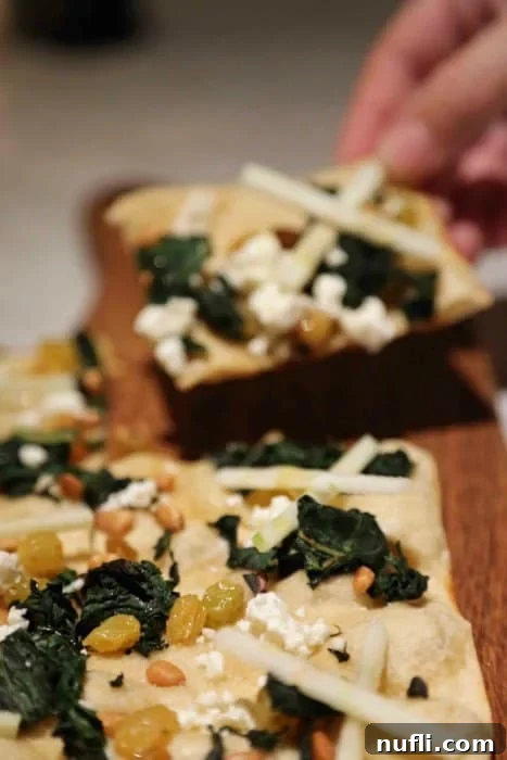 Tarte Provencal featuring vibrant swiss chard, creamy goat cheese, and crisp apples, beautifully presented.