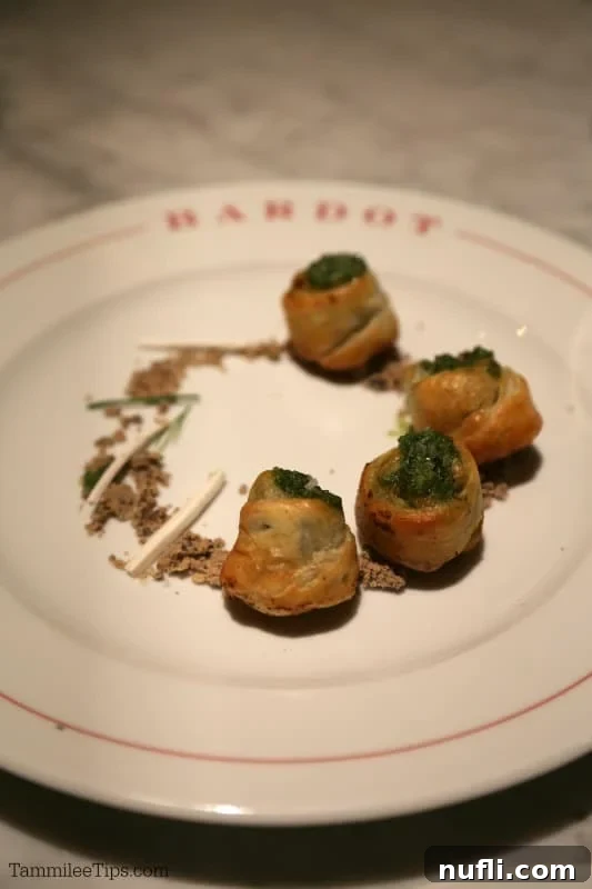 Perfectly cooked escargot elegantly presented on a Bardot plate, ready to be enjoyed.