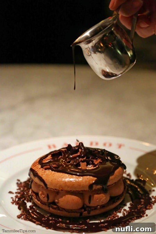 Bardot Brasserie at Aria: An Epicurean Revelation 8 Chocolate dripping over a large chocolate macaron, a truly decadent dessert experience.
