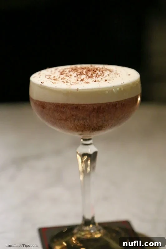 A beautifully crafted cocktail garnished with delicate chocolate shavings, inviting a sensory experience.