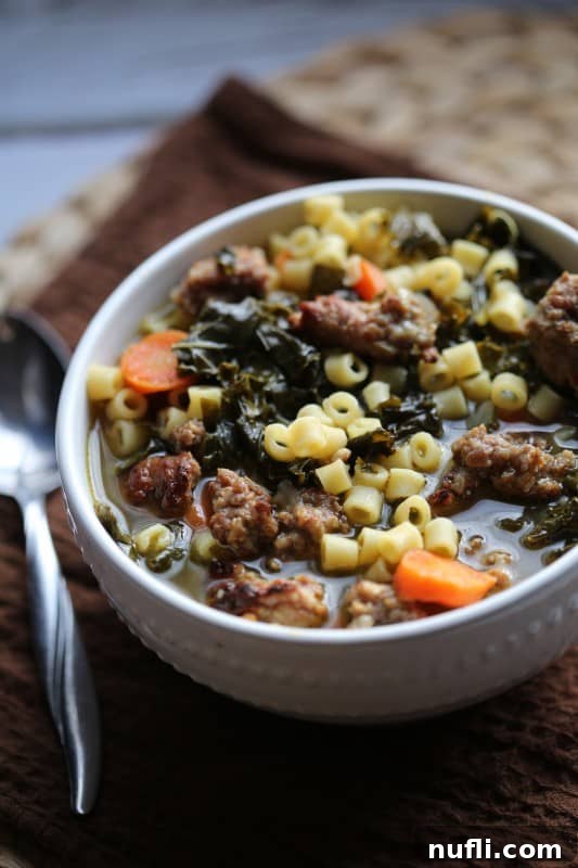 A large serving spoon scooping Crock Pot Italian Sausage Wedding Soup Recipe from a rustic pot, highlighting its hearty nature.