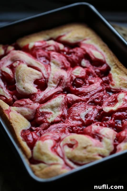 Marbled Cherry Pie Cake Recipe 3 Close-up of a slice of Marbled Cherry Pie Cake, showing the distinct swirls of cherry filling within the moist cake.