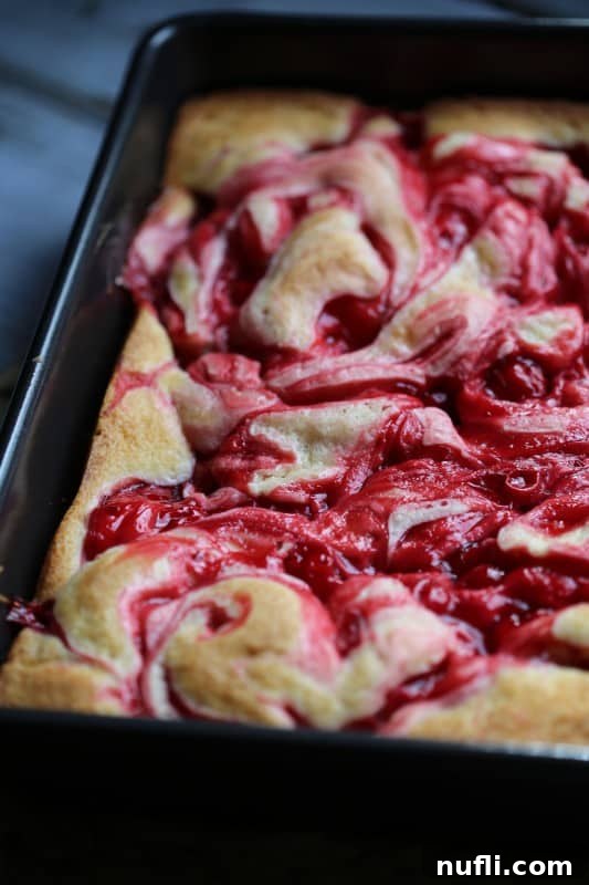 Marbled Cherry Pie Cake Recipe 6 Another view of the Marbled Cherry Pie Cake, highlighting its moist texture and the vibrant red cherry filling swirled throughout the cake.