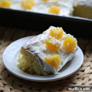 Slice of pina colada poke cake on a white plate