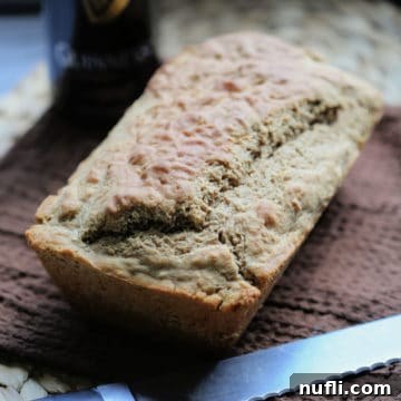 Guinness beer bread next to a knife on a brown cloth napkin