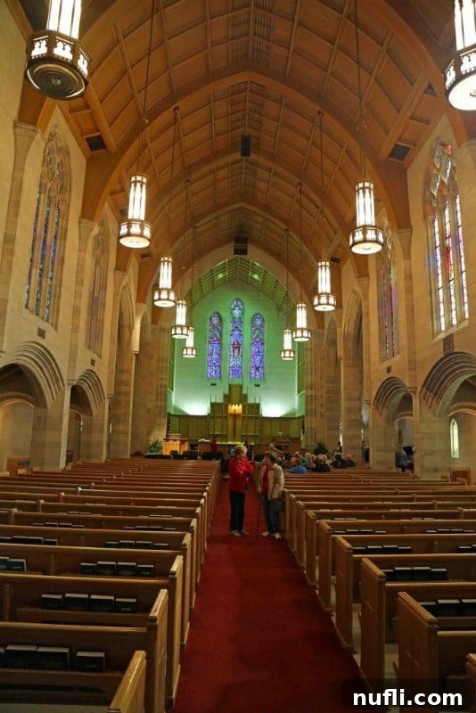 Interior view of the stunning chapel at the College of the Ozarks, featuring exquisite stained glass windows and classic church pews.