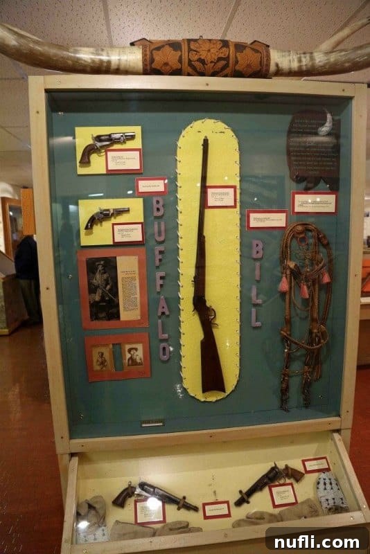 An impressive display of firearms, including Buffalo Bill's gun, at the Ralph Foster Museum, highlighting historical weaponry.