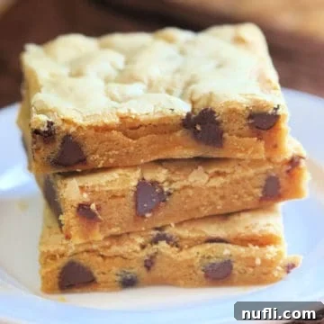 Chocolate Peanut Butter Cake Mix Cookie Bars stacked on a white plate, showcasing their inviting golden-brown edges and moist interior.