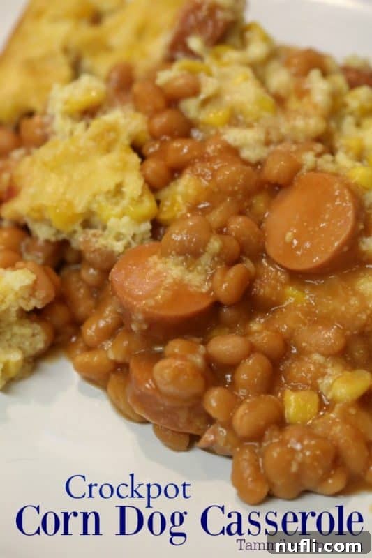 Easy Crock Pot Corn Dog Casserole 2 Crockpot Corn Dog Casserole under a white plate filled with hot dogs, beans and cornbread topping