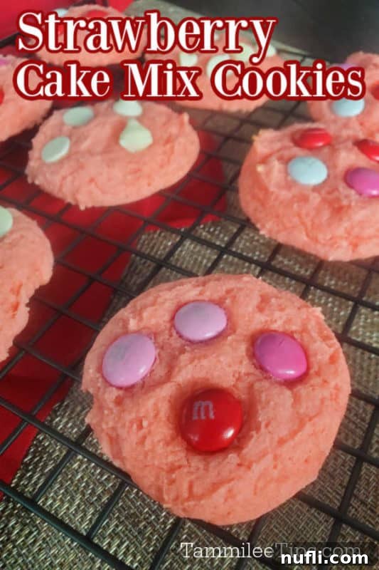 A delicious slice of strawberry cake mix cookie, topped with sprinkles and chocolate chips, resting on a wire rack with more cookies in the background.
