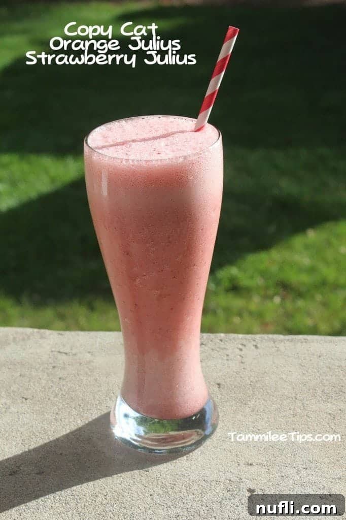 A tall glass filled with a pink, frothy Copycat Orange Julius Strawberry Julius, placed next to text that reads 'Copycat Orange Julius Strawberry Julius'.
