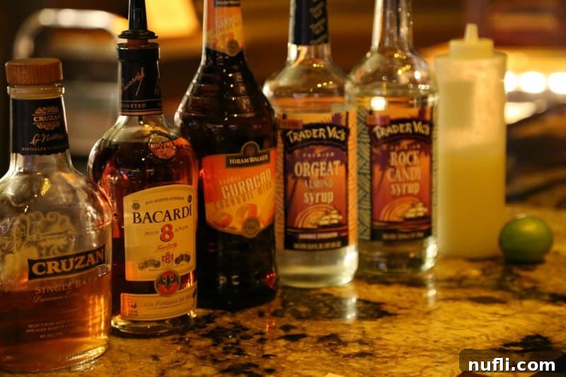 Mai Tai ingredients laid out: Cruzan single barrel rum, Bacardi 8-year rum, Orange Curacao, Orgeat syrup, and Rock Candy syrup, ready for mixing.