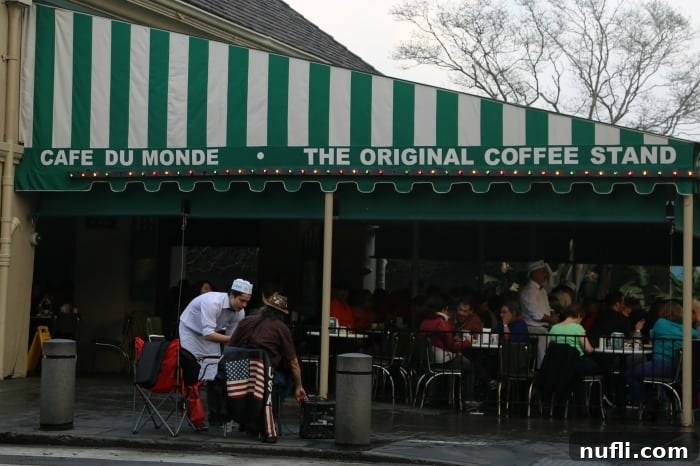 The iconic yellow and white striped awning of Cafe Du Monde, a historic New Orleans landmark.