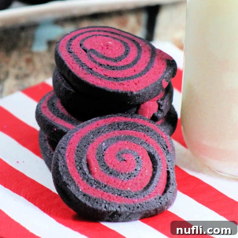 Halloween Pinwheel Cookies on a napkin next to a bottle of milk, featuring spooky colors