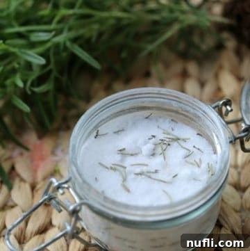 A top-down view of beautiful rosemary mint bath salts in a rustic glass jar
