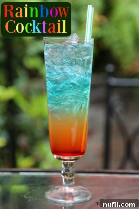 Rainbow cocktail on a table with a green background
